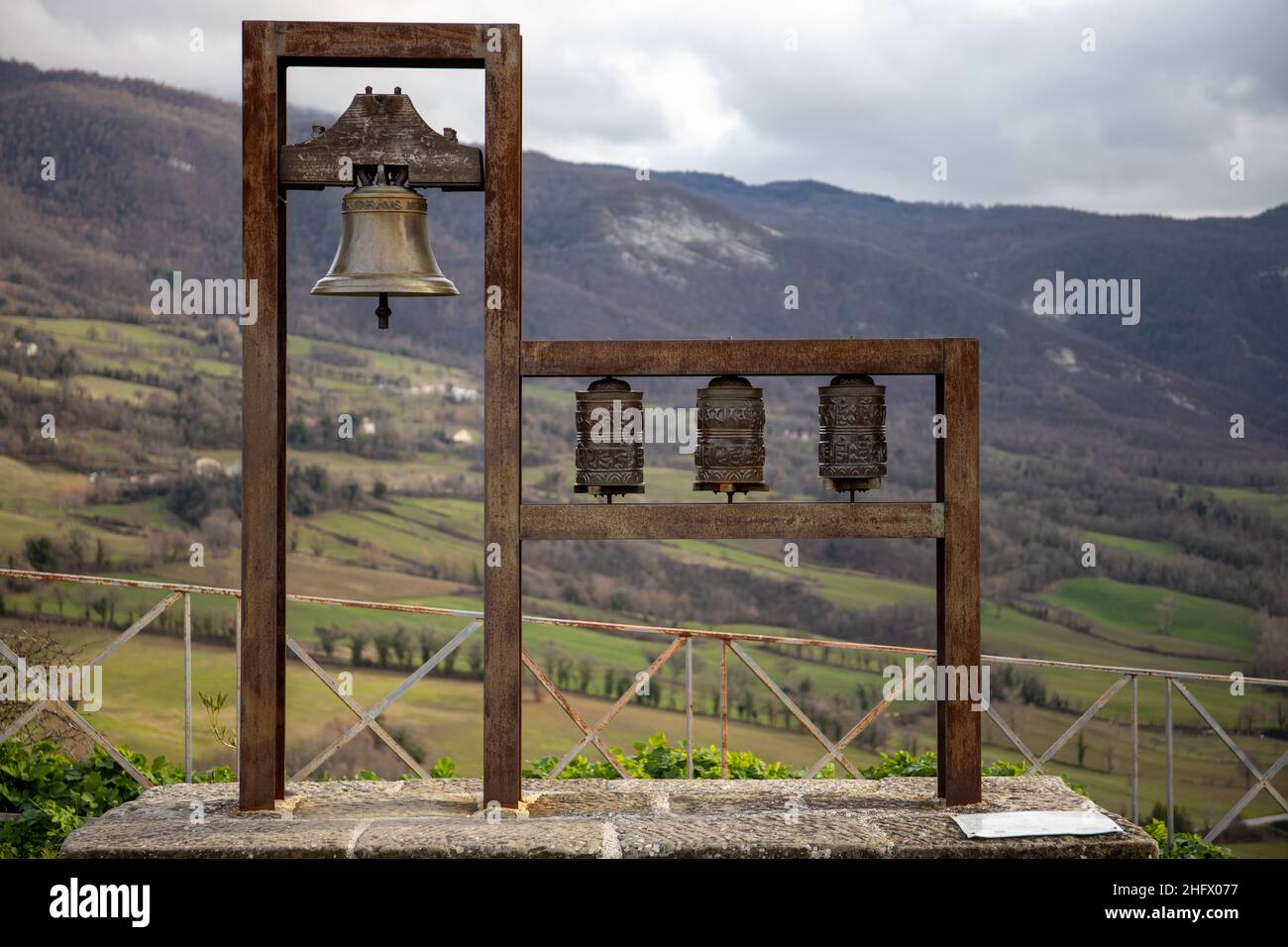 Italy:in the ancient village of Pennabilli a Tibetan bell rings for the union of two religions (next to the bell there are three Tibetan prayer mills) Stock Photo
