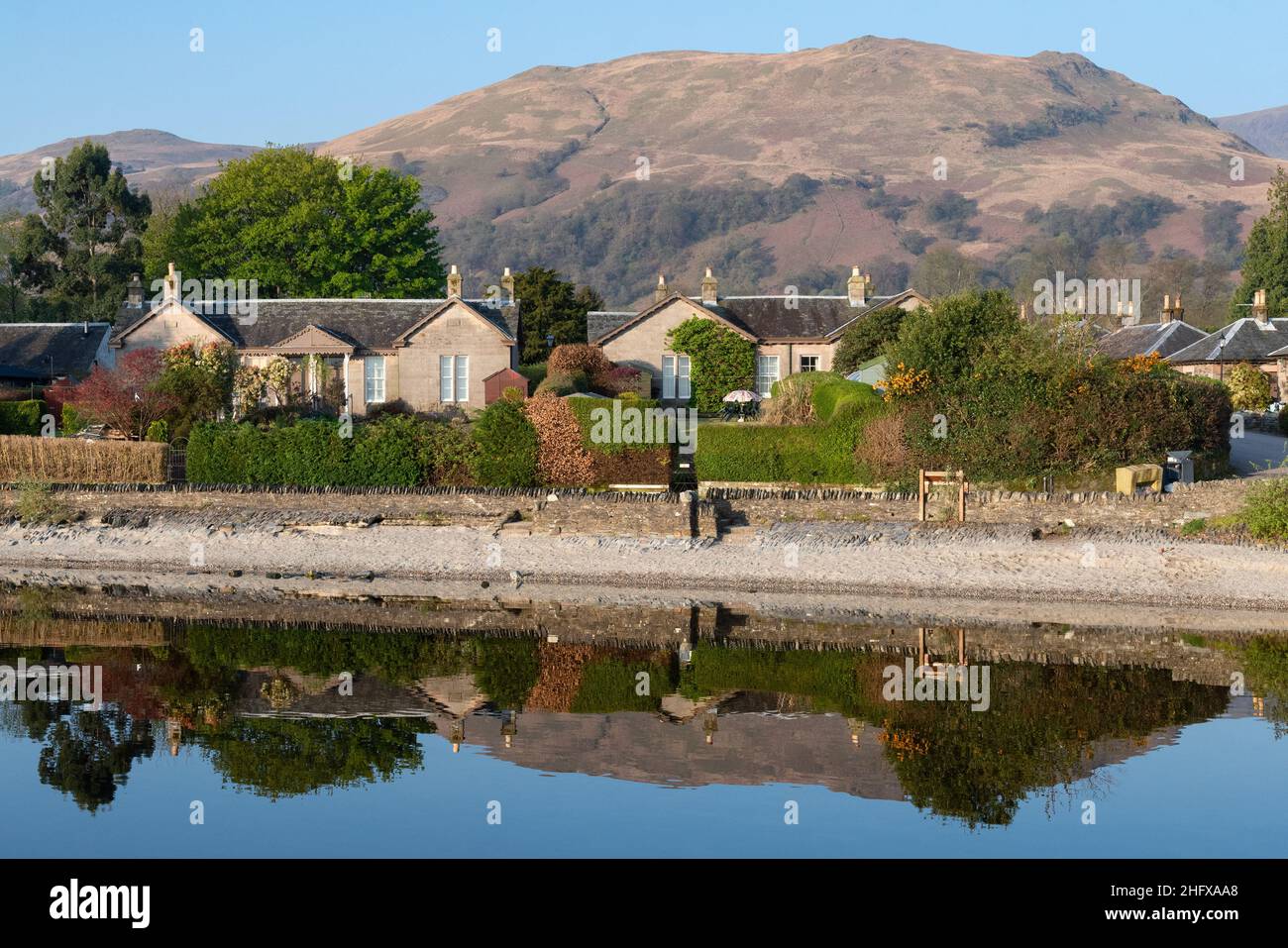 cottages reflected in Loch Lomond, Luss, with the Luss Hills behind