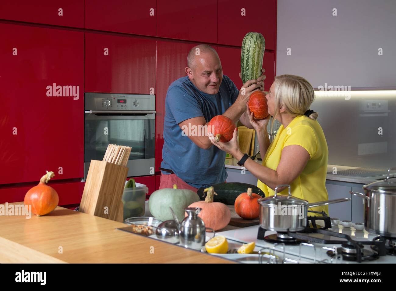 Family fun. Happy wife and husband having fun and joking in the kitchen while making dinner Stock Photo