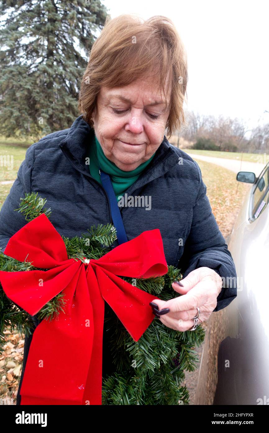 Woman delivering a wreath to parents grave in the cemetery. Minneapolis Minnesota MN USA Stock Photo