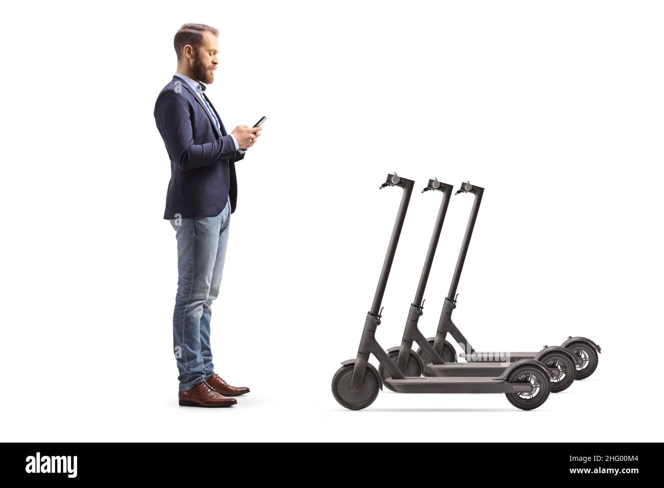 Full length profile shot of a man in suit and jeans renting an electric scooter isolated on white background Stock Photo