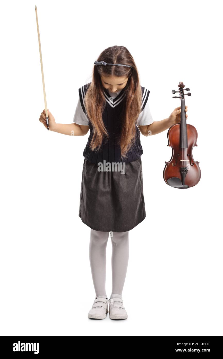 Full length portrait of a schoolgirl in a uniform holding a violin and ...