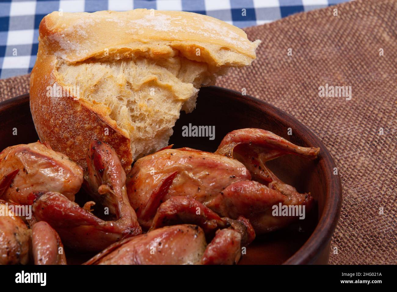 Rustic dinner. Roasted quail meat and white bread. Closeup Stock Photo Alamy