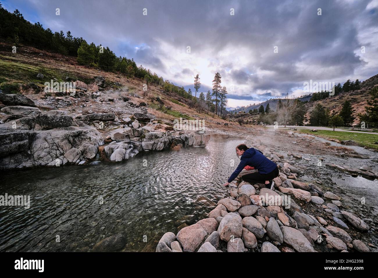 A young woman feeling the water temperature at Kirkham hot springs Stock Photo Alamy