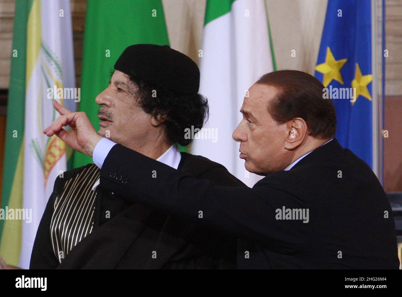 Italian Premier Silvio Berlusconi, right, talks to Libyan leader Moammar Gadhafi prior to the start of a joint press conference at Rome's Villa Madama, Gadhafi is on a three-day official visit to Italy. Stock Photo