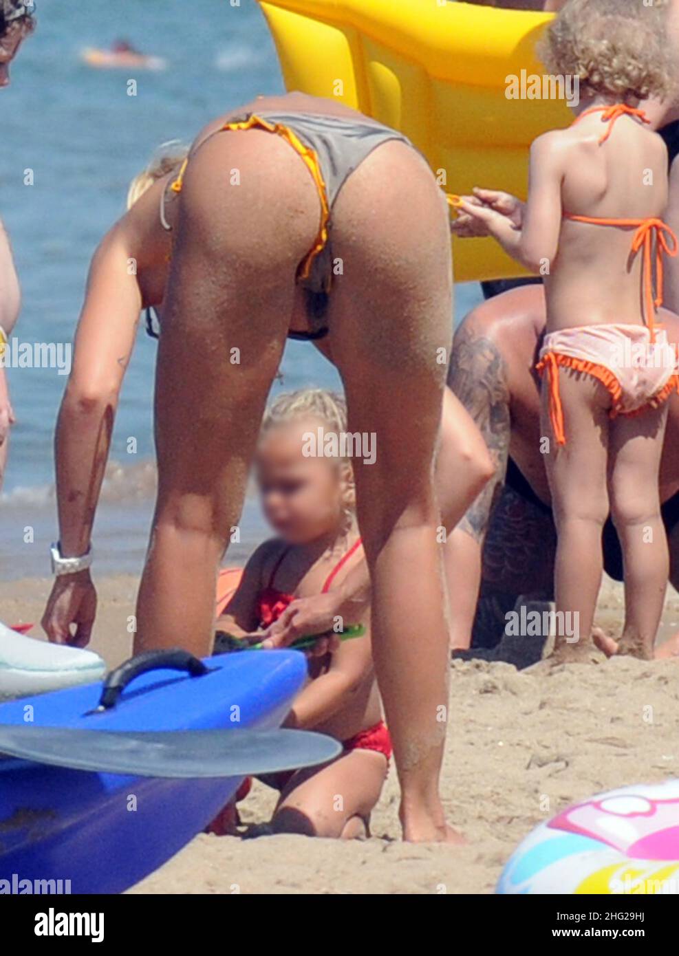 Ilary Blasi, wife of soccer player Francesco Totti, relaxing on the beach with her kids Cristian and Chanel (faces blurred) in the coastal town Sabaudia in Lazio, Italy. Stock Photo