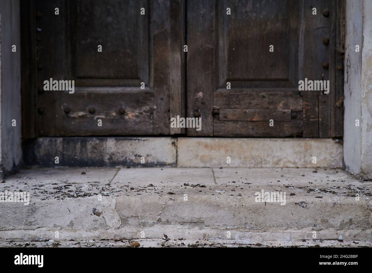 bird or pigeon poop on old stone doorstep in front of old wooden Stock