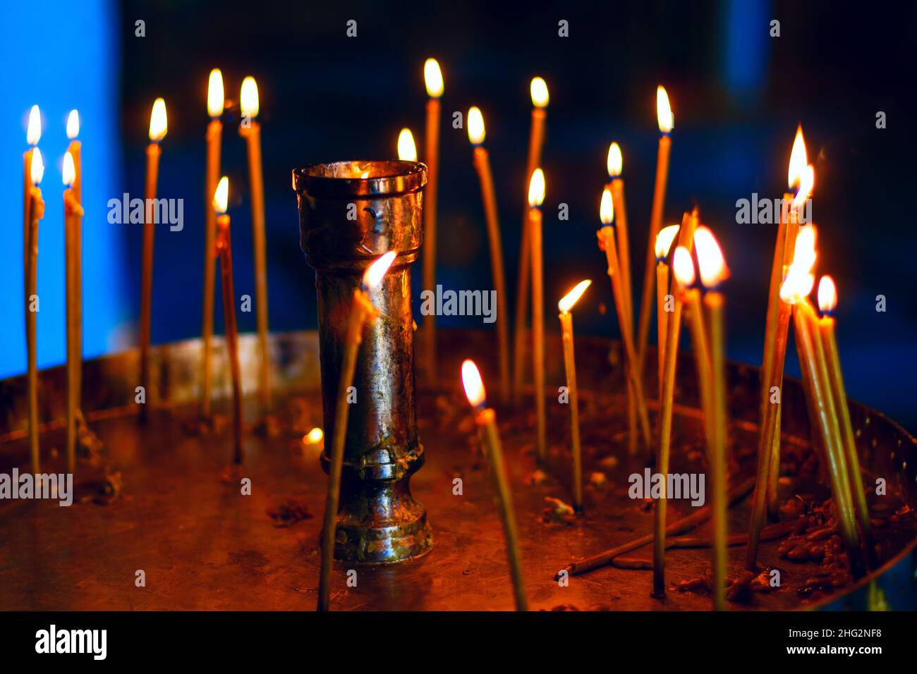 Lighting candles in the church . Praying with burning candles Stock