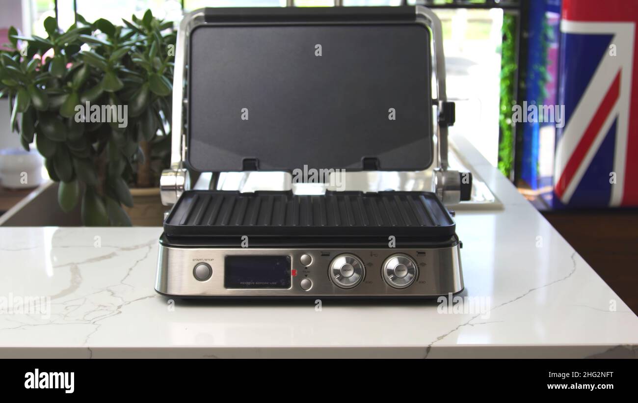 Home use electric grill on polished white table at the shop of home