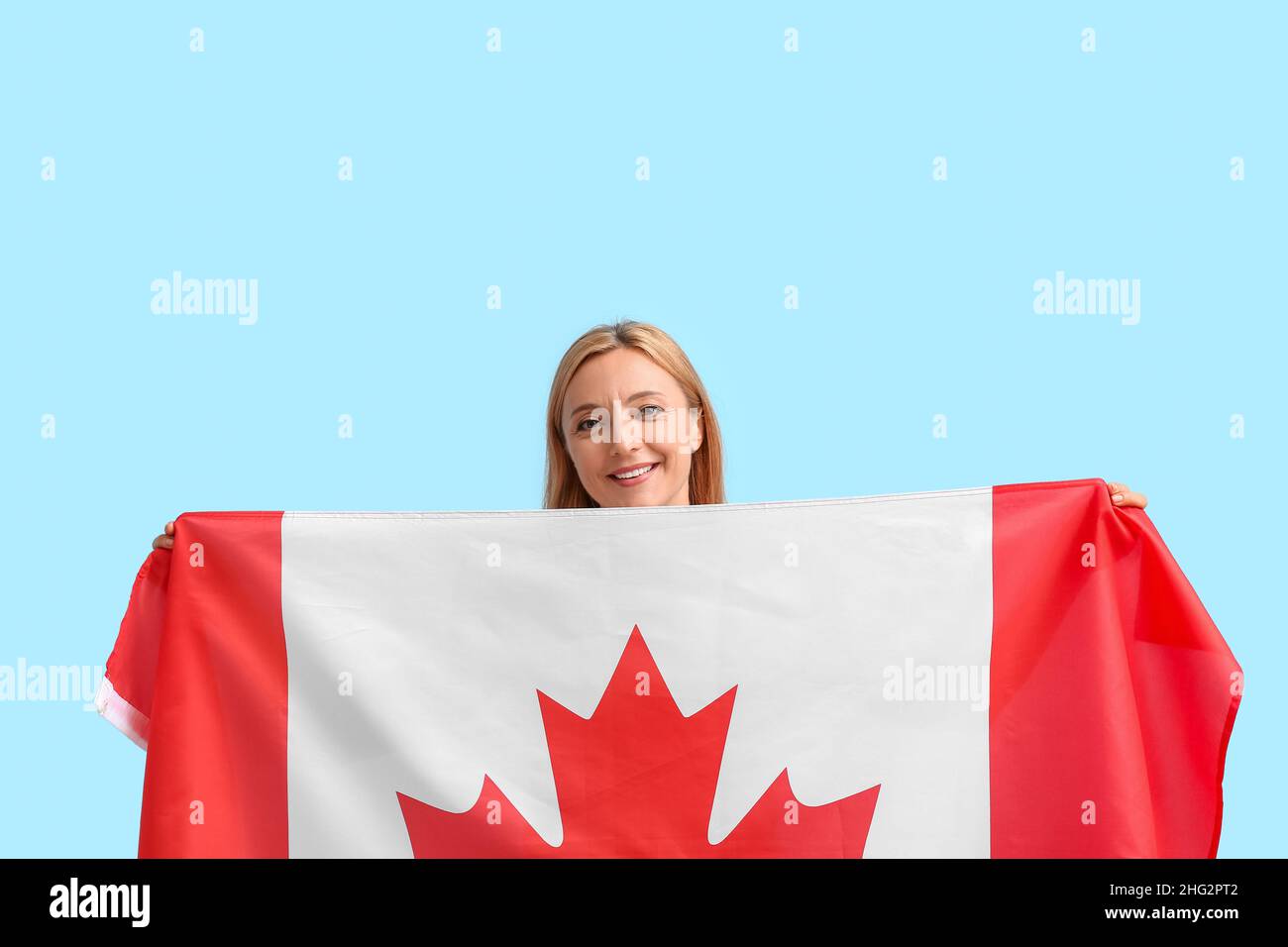 Mature woman with Canadian flag on color background Stock Photo - Alamy