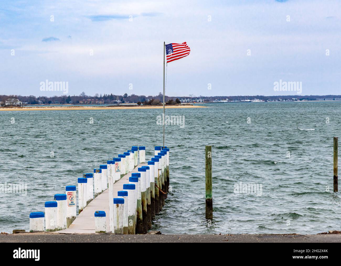 Dock with a flag at the end Stock Photo