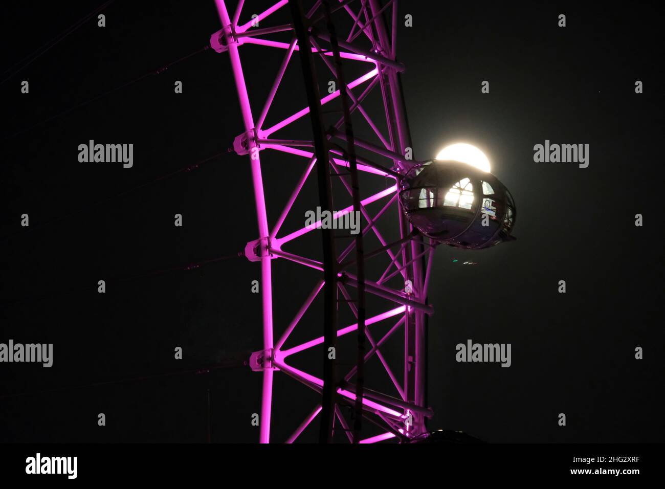 London, UK, 17th Jan, 2022. The first full moon of the year - the Wolf Moon passes behind a pod on the London Eye. Credit: Eleventh Hour Photography/Alamy Live News Stock Photo