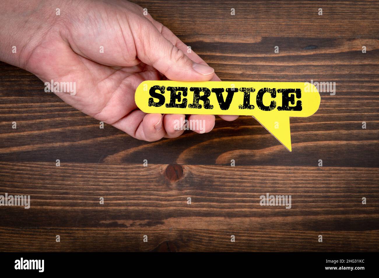 SERVICE. Yellow speech bubble on a dark wood texture background Stock ...