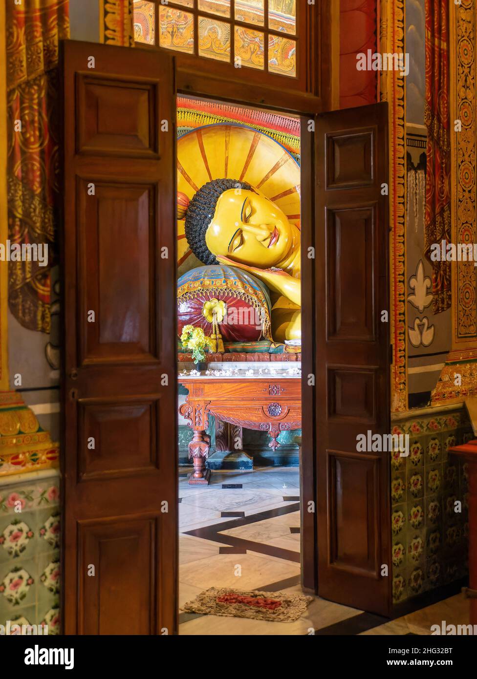 Interior of the Asokaramaya Buddhist Temple, Colombo, Sri Lanka, with a sleeping Buddha image visible through a door. Stock Photo