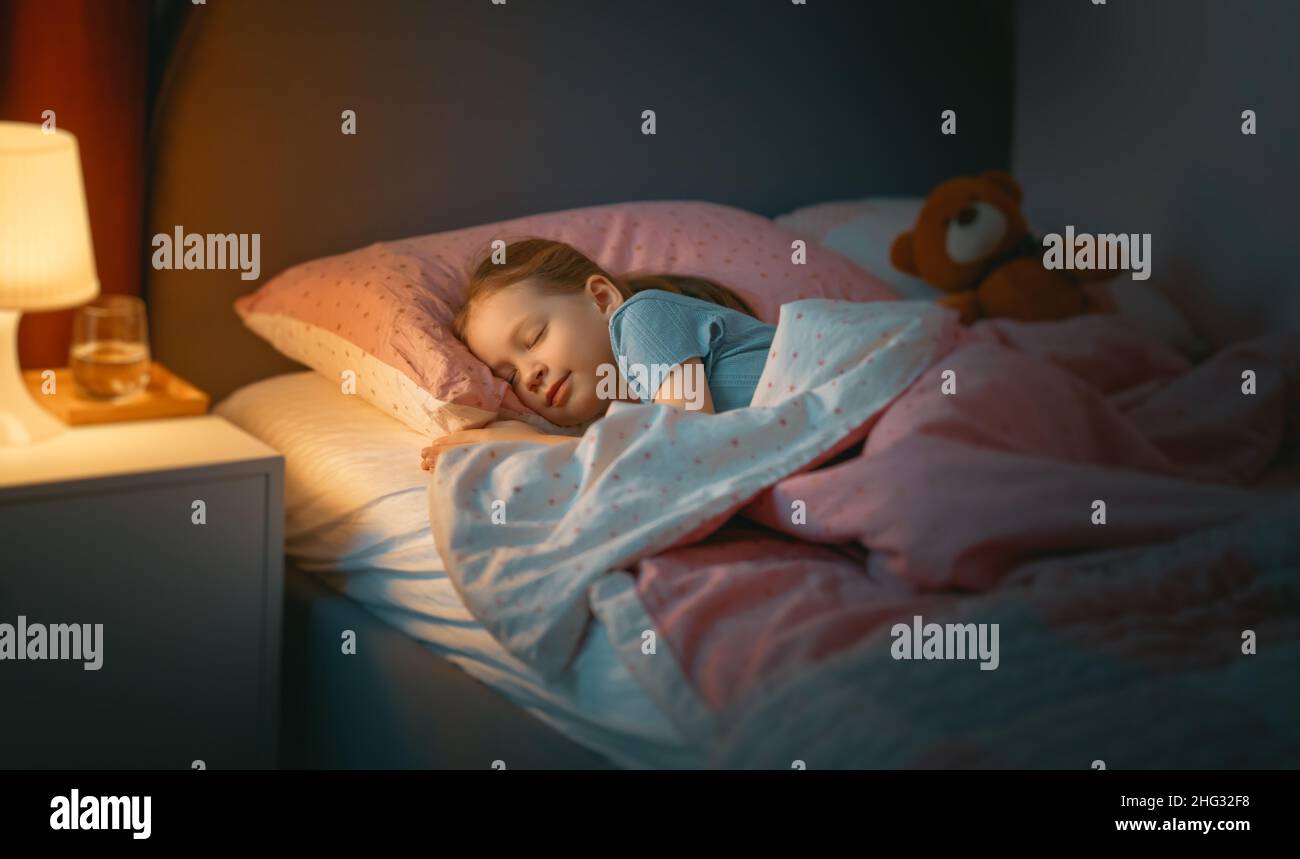 Adorable little child is sleeping in the bed Stock Photo - Alamy