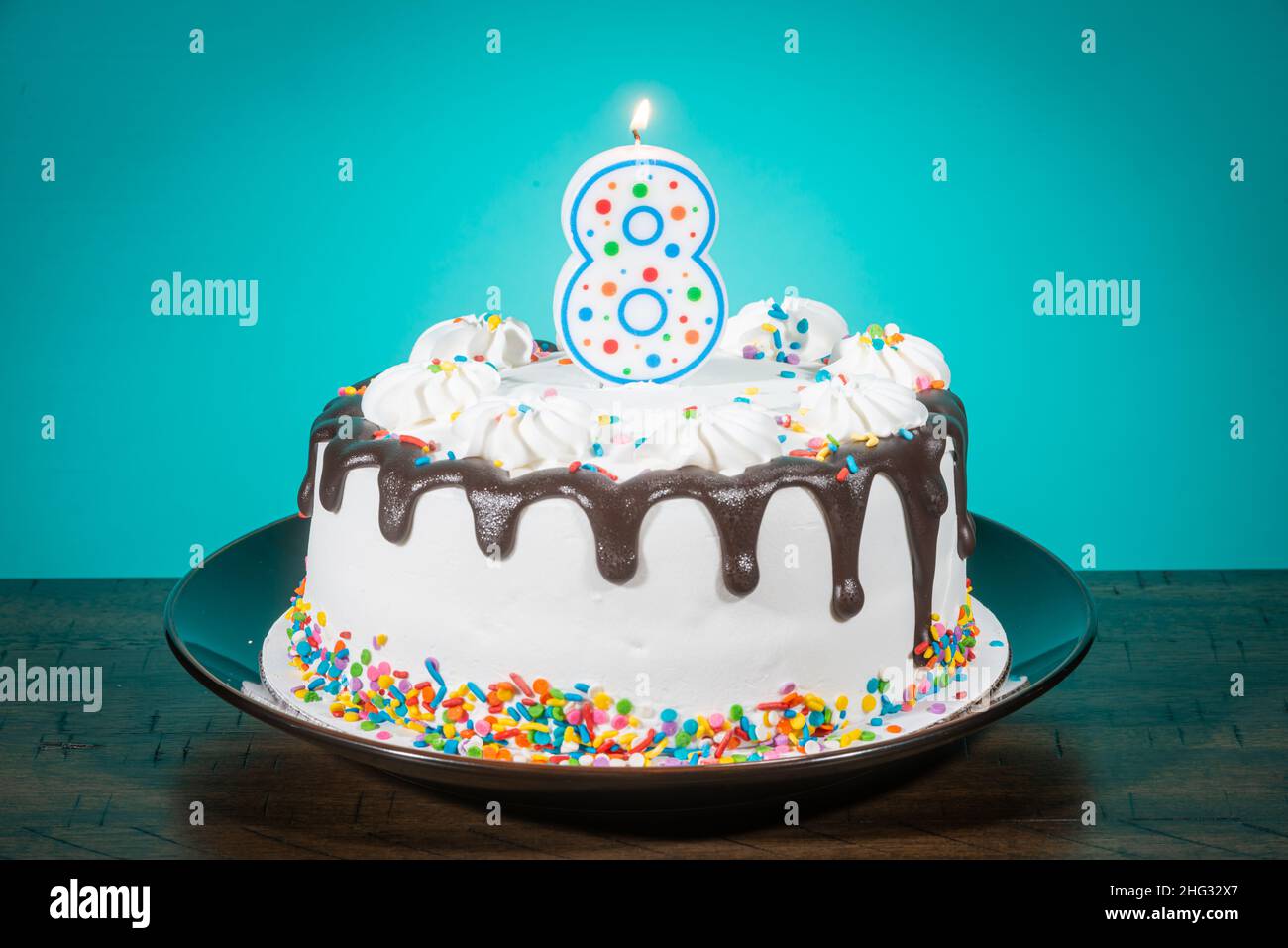A birthday cake bears a candle in the shape of the number 8. Stock Photo