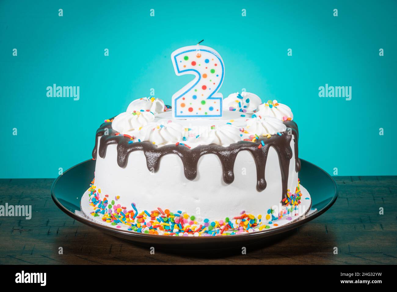 A birthday cake bears a candle in the shape of the number 2. Stock Photo