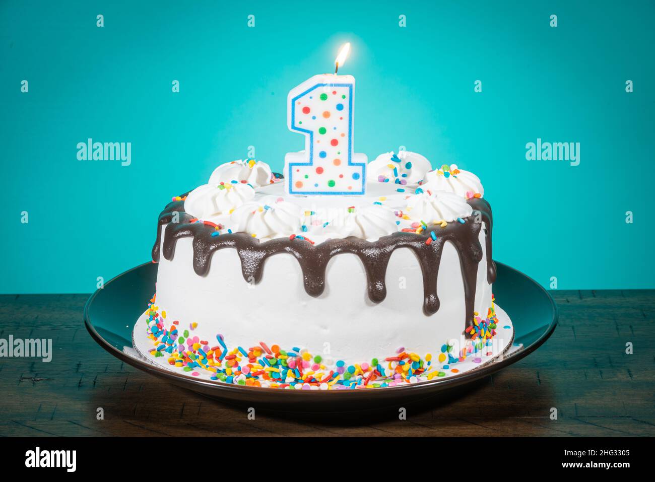 A birthday cake bears a candle in the shape of the number 1. Stock Photo