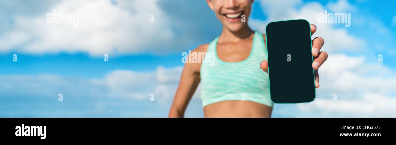 Phone with black screen for fitness app exercise at home or outside in summer active lifestyle. Banner of woman holding technology device showing use Stock Photo