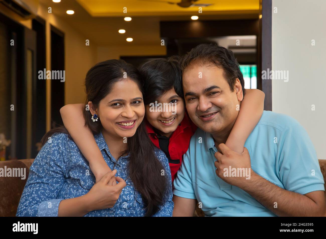 Young boy posing in front of camera with her parents Stock Photo