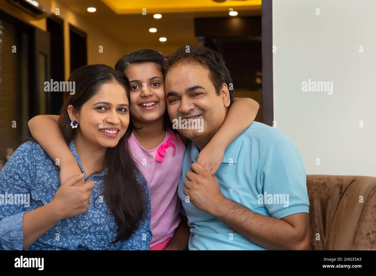Young girl posing in front of camera with her parents Stock Photo