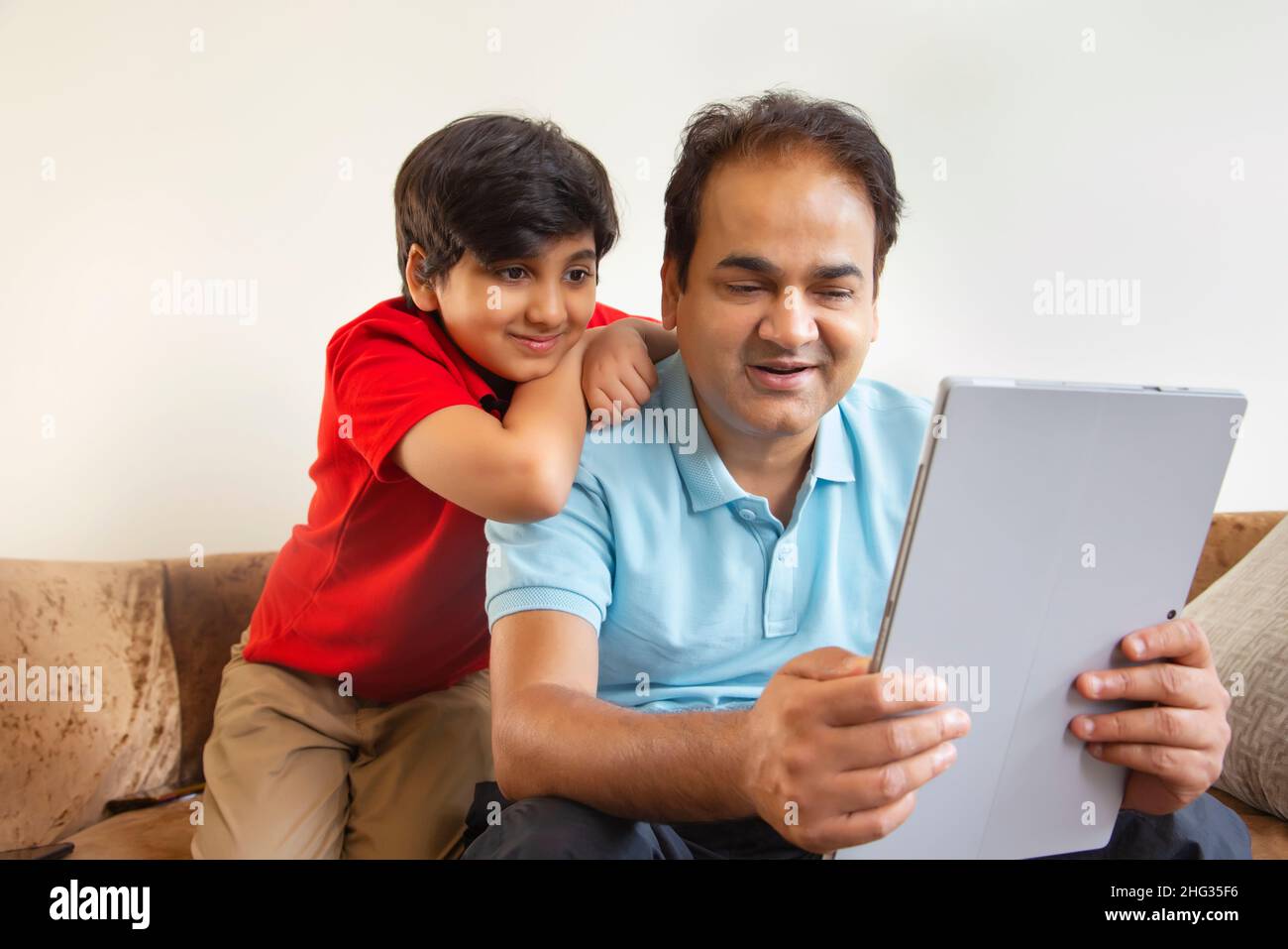 Father and son together watching laptop Stock Photo