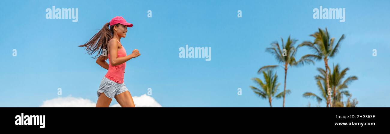 Running woman. Asian fitness girl runner working out exercising against blue sky background with palm trees. Panoramic banner Stock Photo