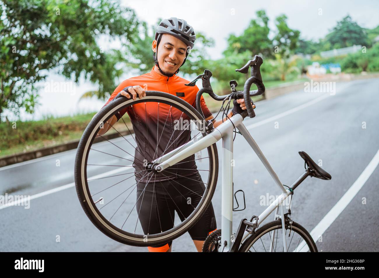 Asian male cyclist checking hi-res stock photography and images - Alamy
