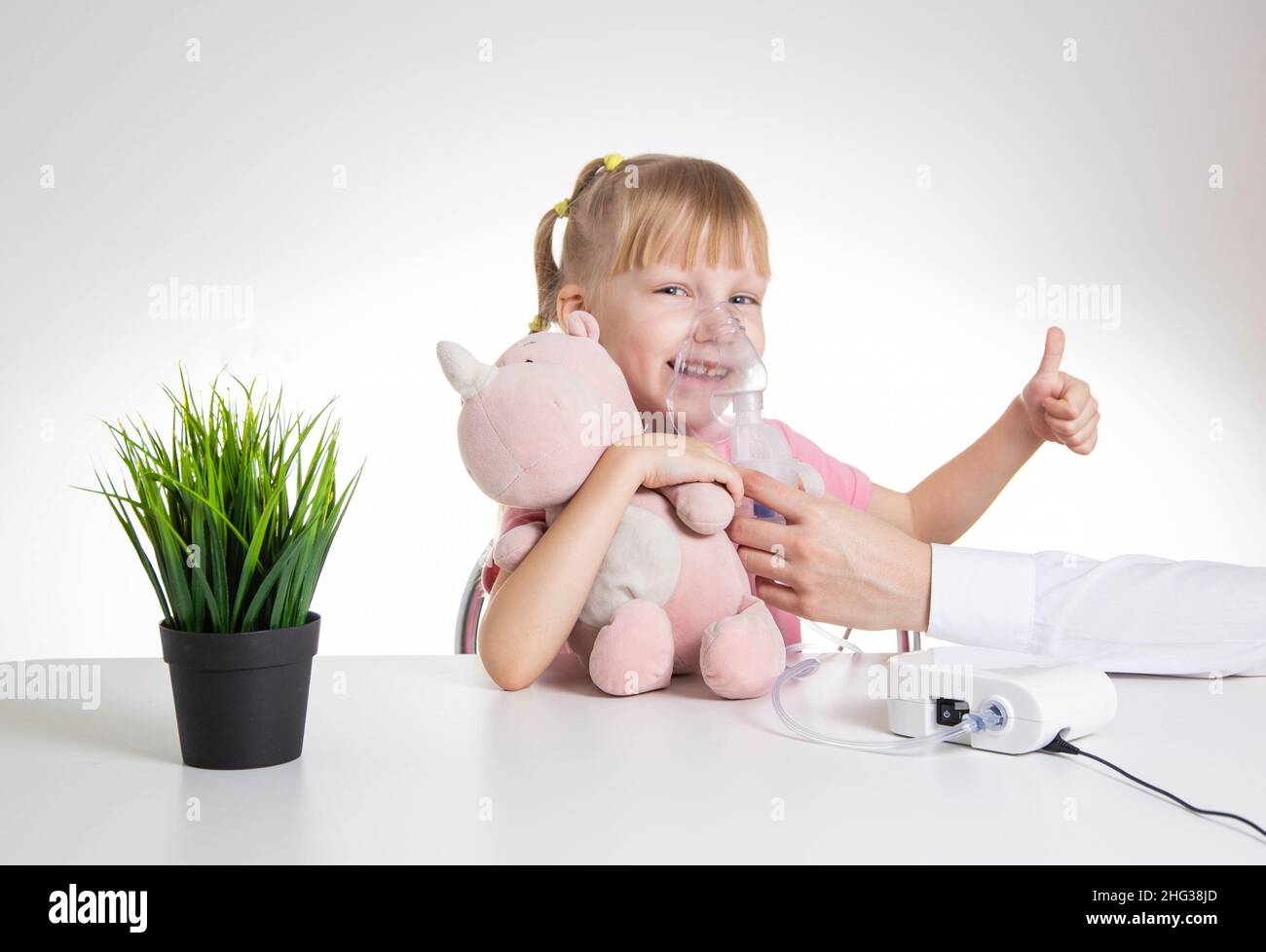 A 5-year-old girl is breathing into an inhaler at home. Treatment of cough and lung diseases in children, dilution of phlegm in the bronchi. Stock Photo