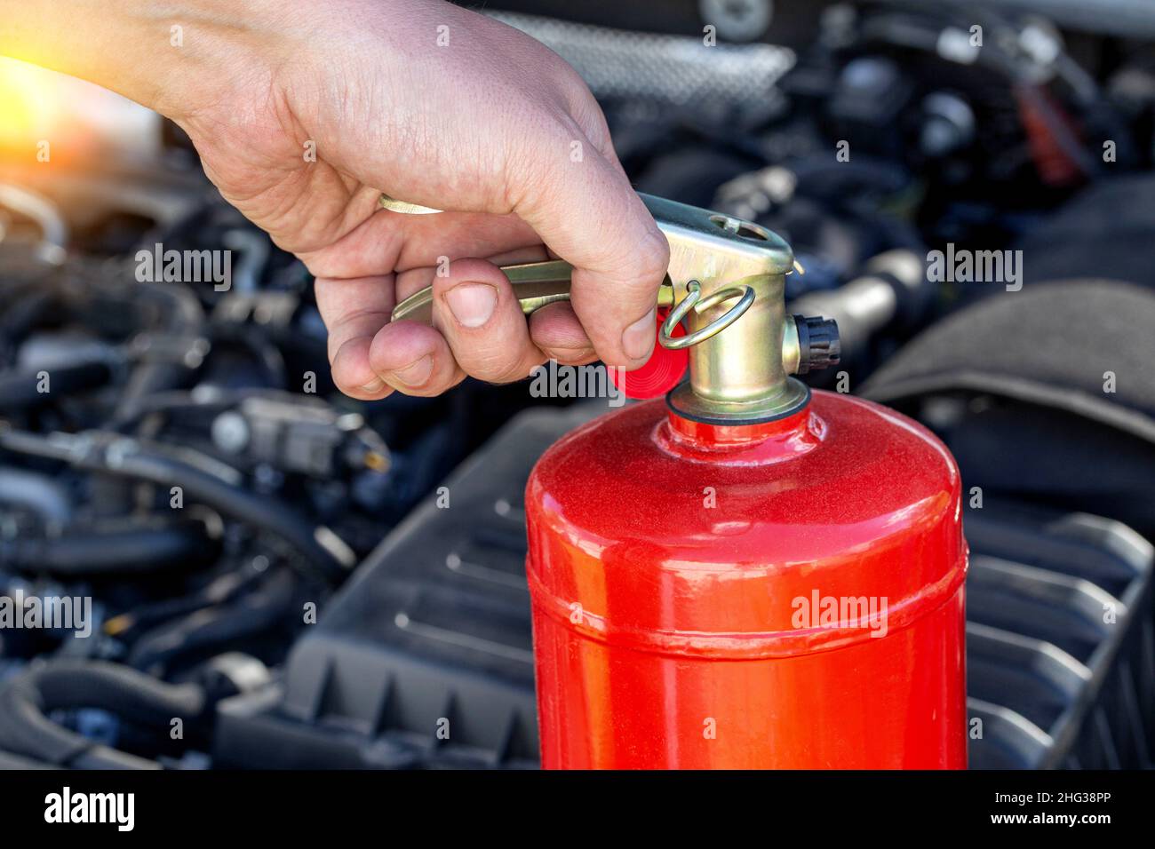 Car fire extinguisher on the background of the car engine
