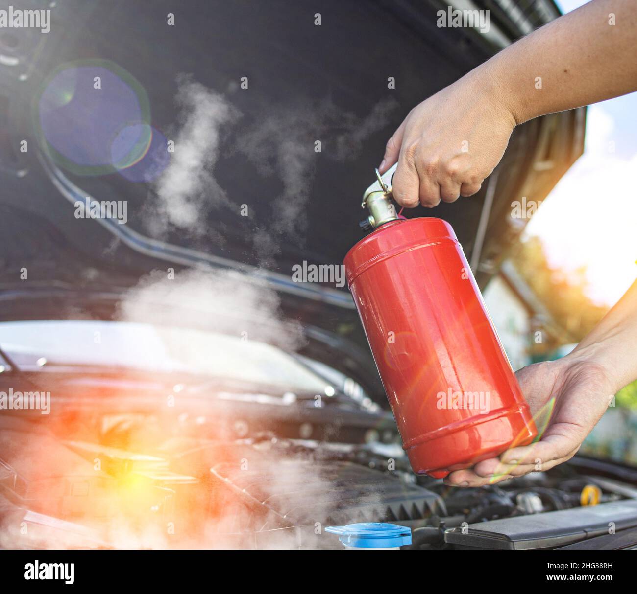 The driver of the car directs a powder fire extinguisher at the engine