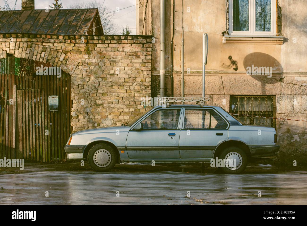 An old gray car in the courtyard of a residential building, Latvia, Riga, January 2022 Stock Photo