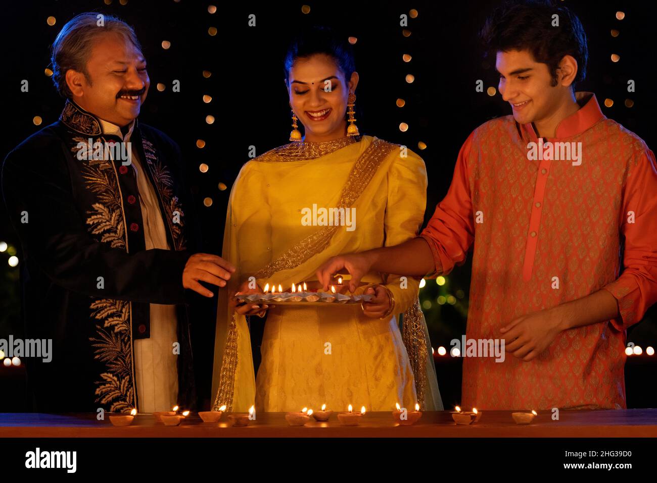 Indian family decorating house by diyas on Diwali Stock Photo