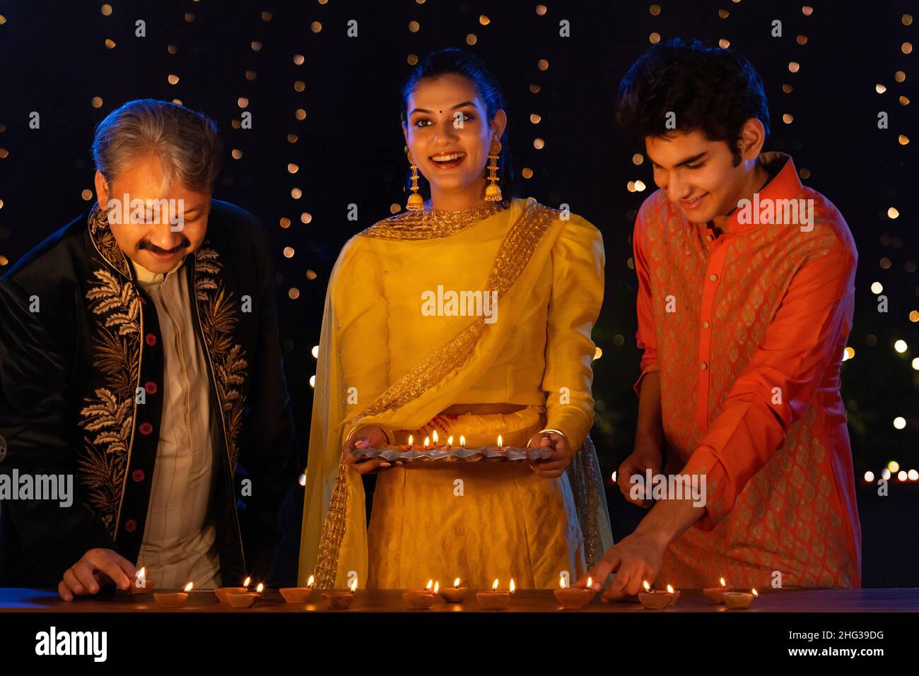 Indian family decorating house by diyas on the occasion of Diwali Stock Photo