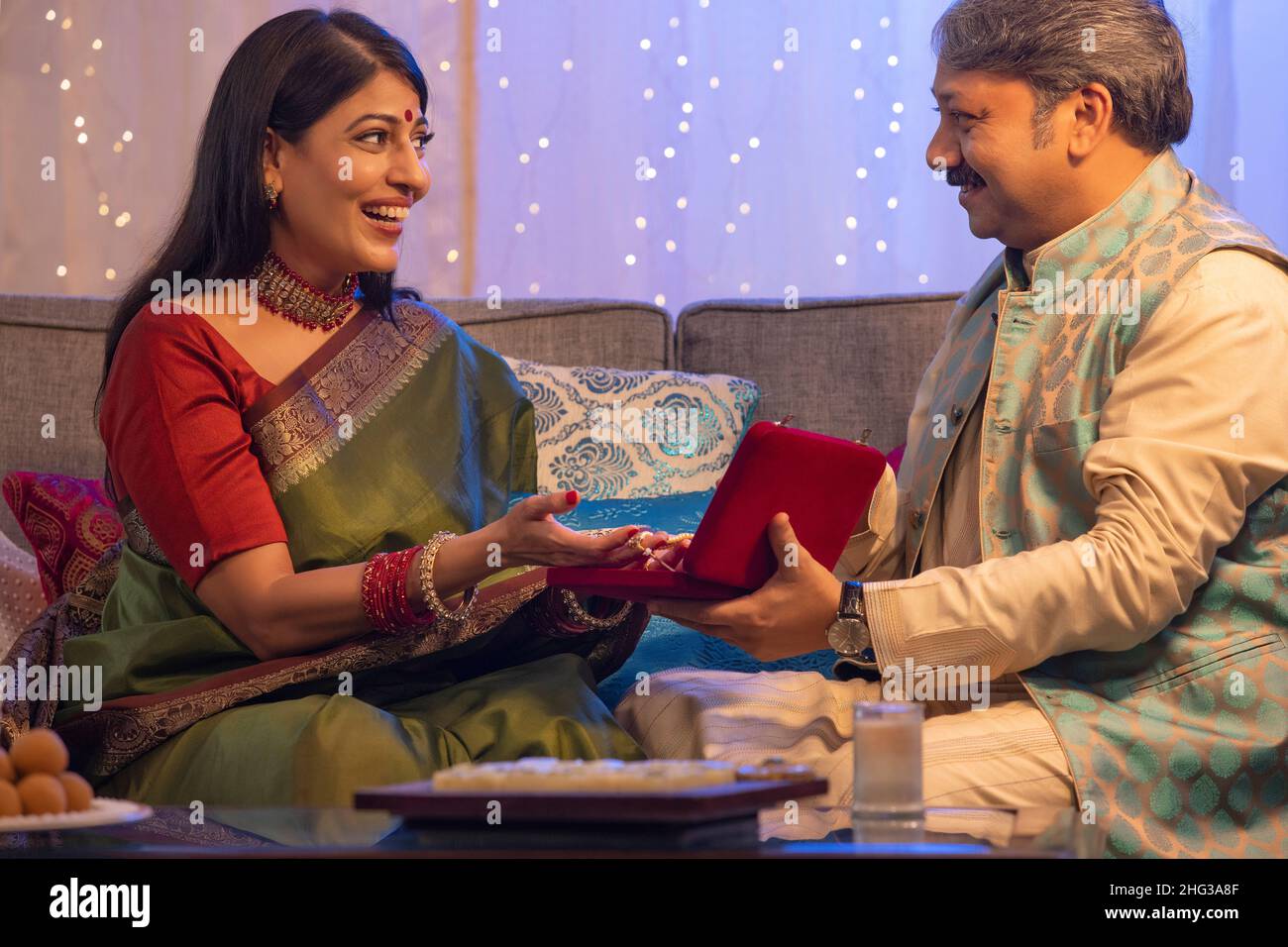 Woman happily accepting gift given by her husband on Diwali Stock Photo