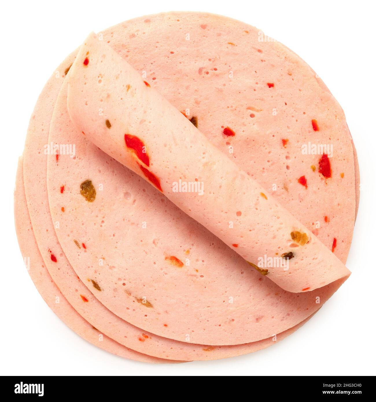 Three slices of paprika lyoner ham isolated on white. One rolled up. Top view. Stock Photo