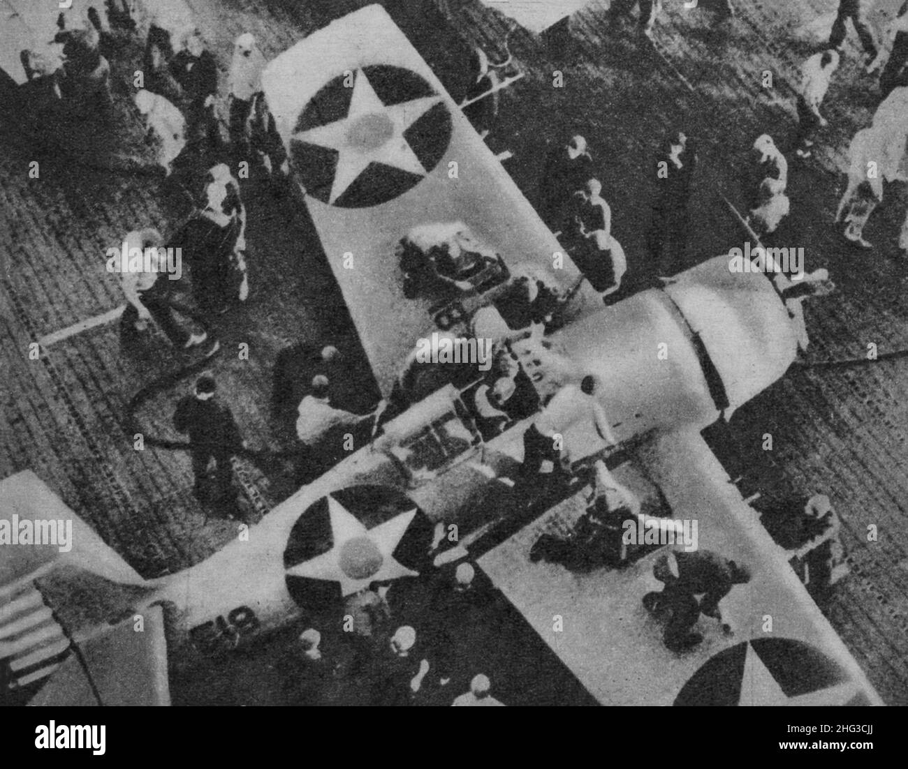 Vintage photo of an American aircraft, after operating on Japanese bases in the Pacific, returns to its aircraft carrier to refuel. A specialized team Stock Photo