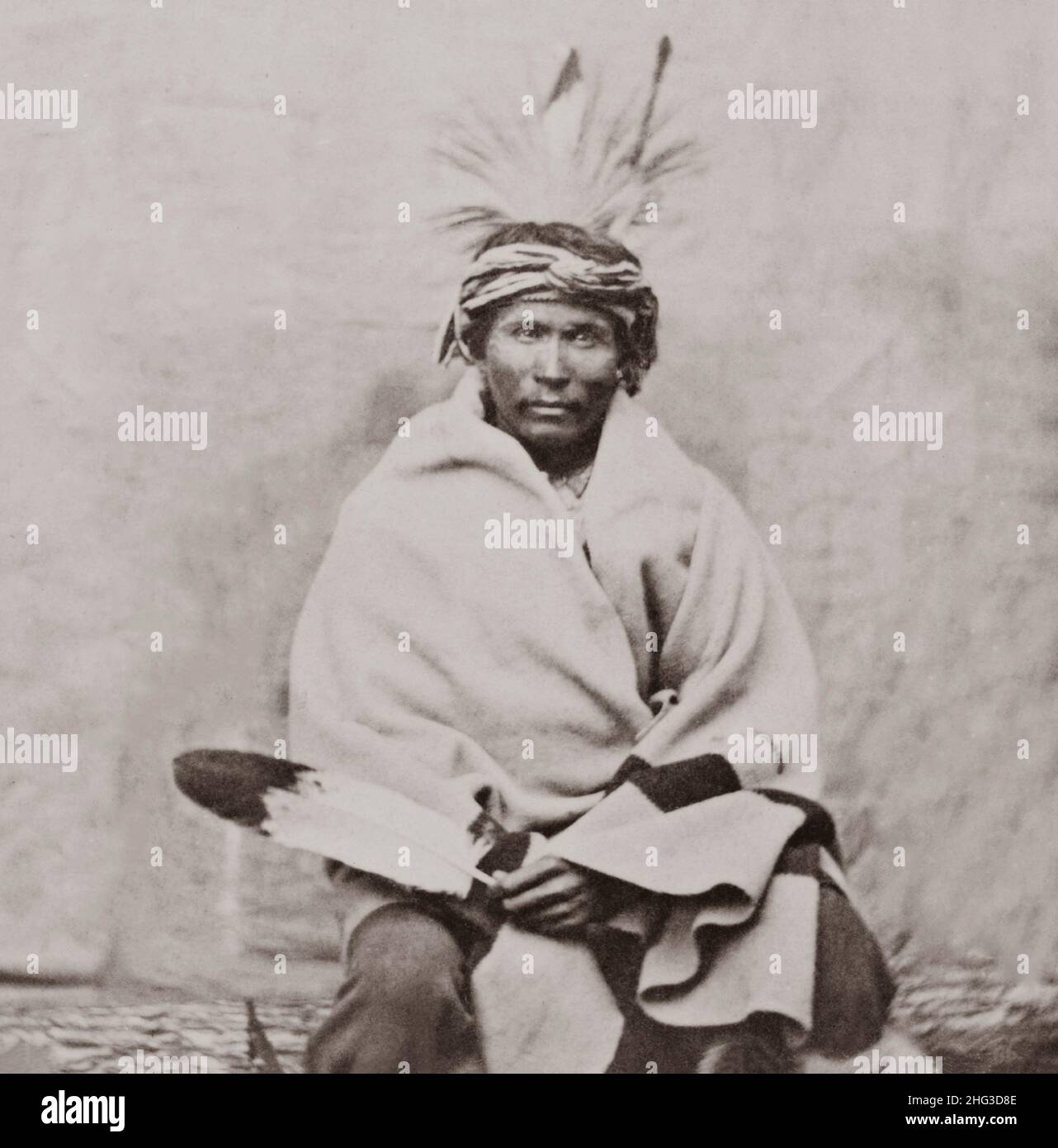 Vintage photo of Winnebago man, three-quarter length portrait, facing front, seated, wrapped in blanket. USA. 1868-1880 Stock Photo