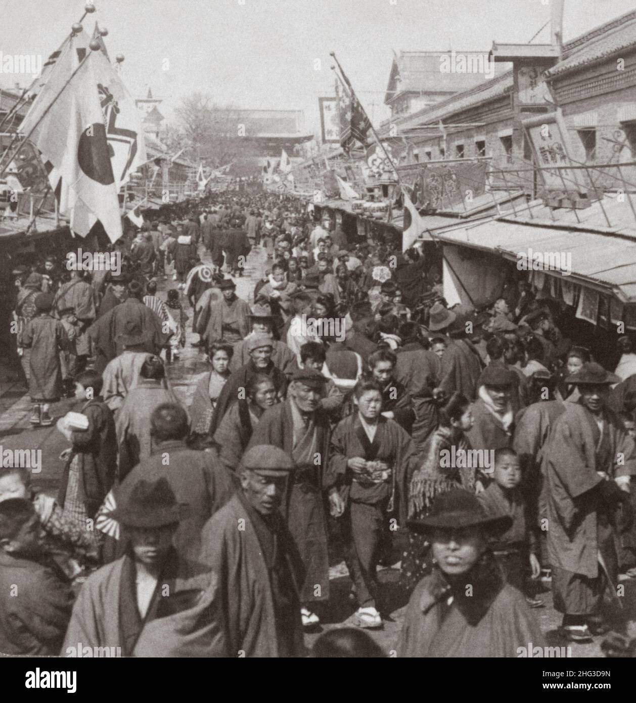 Vintage photo of the 19th century Japan. Crowds in the street leading to Asakusa Park, the famous recreation quarter of Tokyo, Japan. 1905 Stock Photo