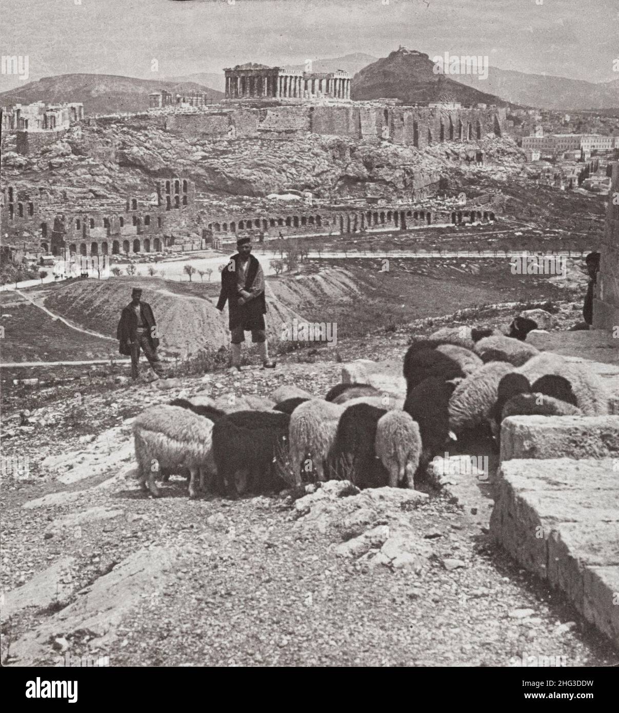Vintage photo of the Acropolis and Lykabettos (royal palace at right), Athens, Greece. 1907 Photograph shows herd of sheep grazing and two men standin Stock Photo
