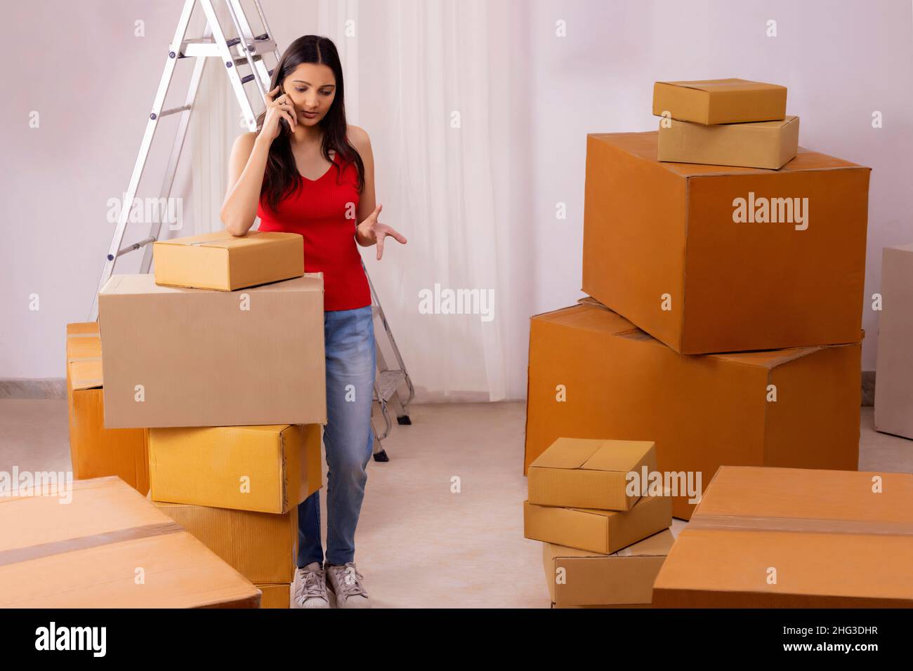 Adult girl talking on Smartphone during packing Stock Photo - Alamy