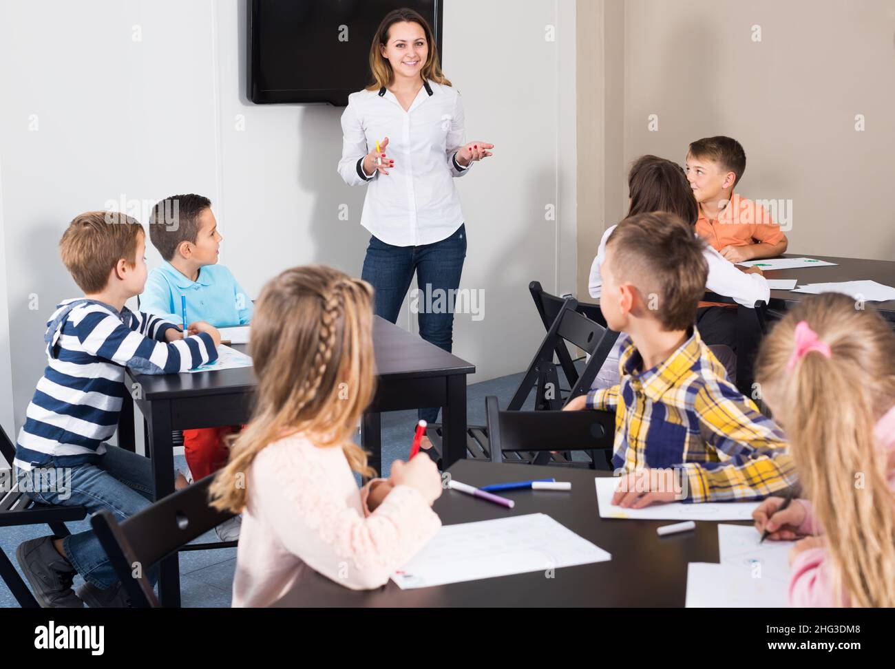 Little children with young teacher drawing in classroom Stock Photo - Alamy