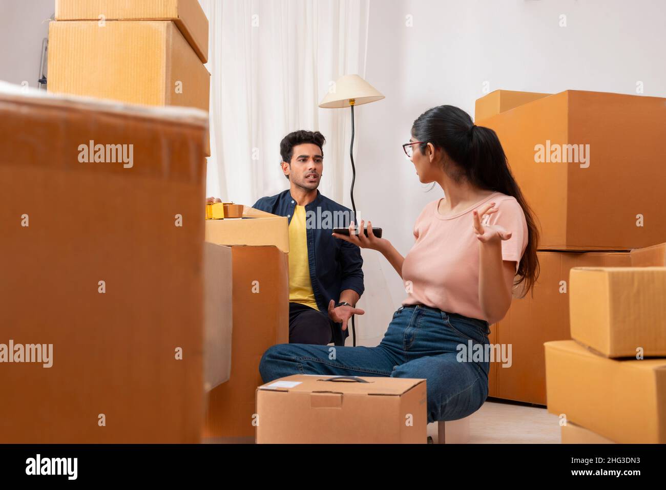 Adult boy and girl talking with each other during packing Stock Photo ...