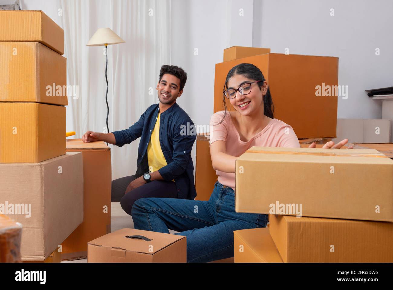 Girl placing cardboard box and the boy observing Stock Photo - Alamy