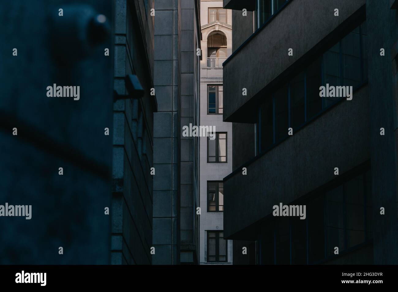 Windows of a commercial office building beyond an alleyway, surveilled by a CCTV camera in the city of london, london, UK Stock Photo