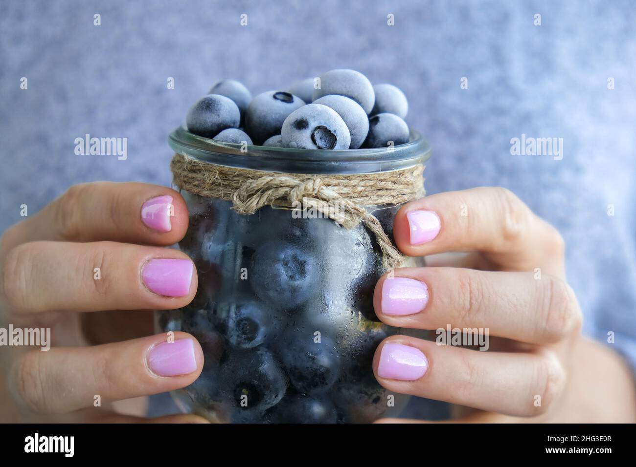 Woman holding bowl with Frozen blueberry fruits. Harvesting concept