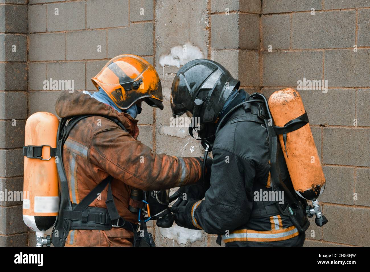 Group of firefighters getting ready for a rescue in a structure surrounded by smoke Stock Photo