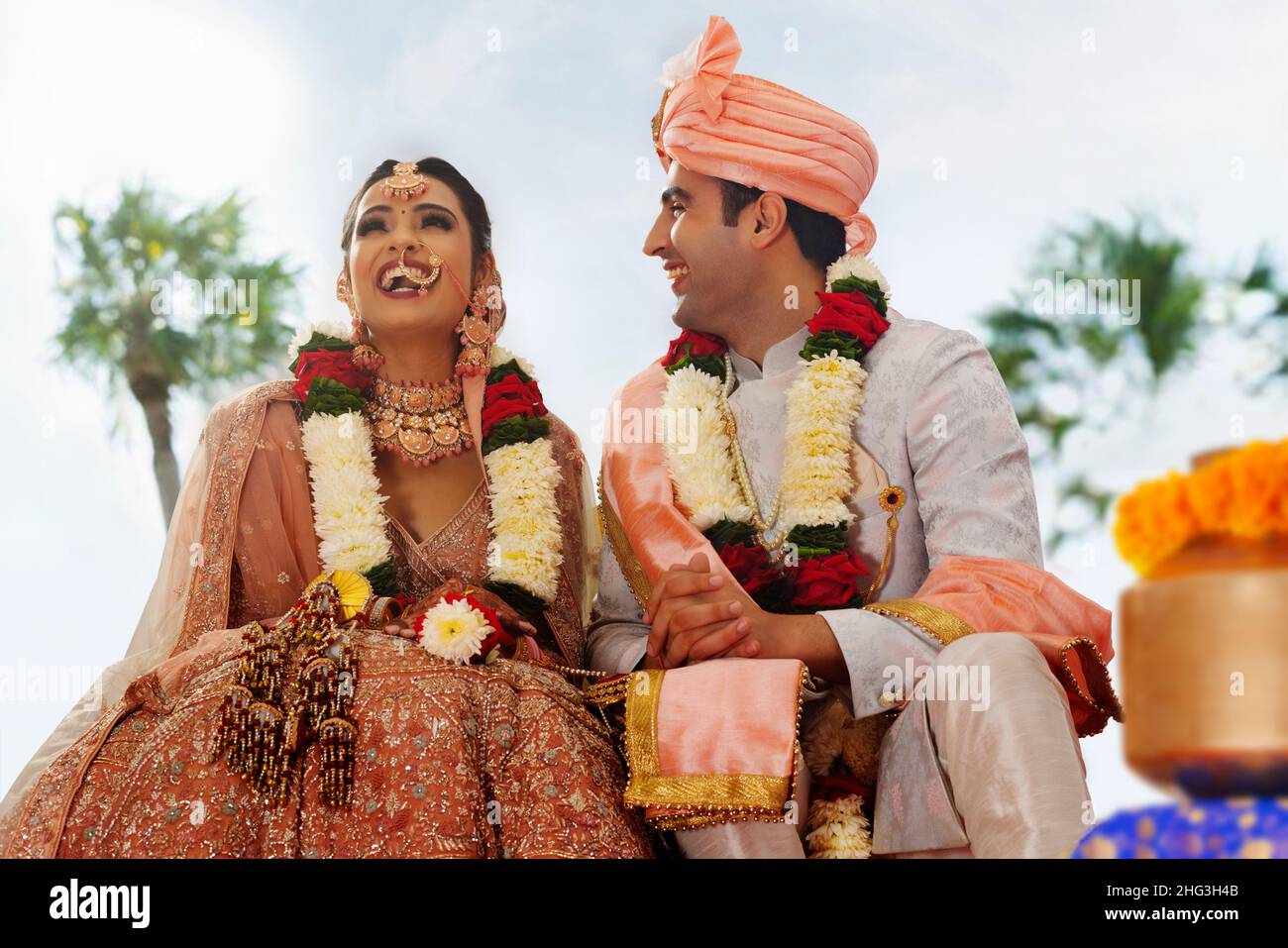 Happy bride and groom sitting together at wedding mandap Stock Photo