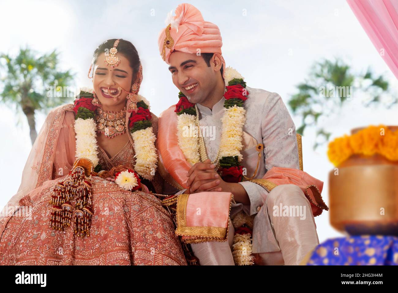 Happy bride and groom sitting together at wedding mandap Stock Photo