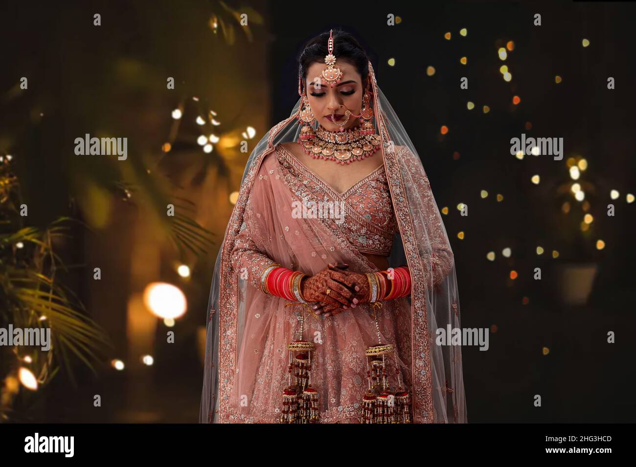 Indian woman in traditional wedding outfit standing in front of camera Stock Photo